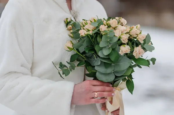 A beautiful wedding bouquet in the hands of the bride. A bouquet with white roses in the hands of the bride