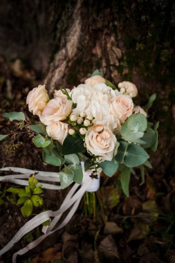 Bir buket beyaz çiçekte bir çift altın alyans. Bir buket gülün üzerinde altın yüzükler