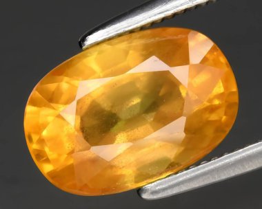 Arka planda doğal sarı safir taşı var.