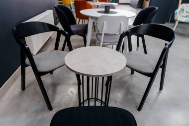 Gri ahşap masa ve yumuşak kumaş döşeme ile siyah tahta sandalyeler.