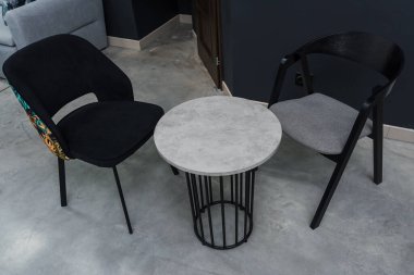 Gri ahşap masa ve yumuşak kumaş döşeme ile siyah tahta sandalyeler.