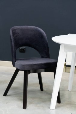 Beyaz ahşap masa, siyah ve beyaz tahta sandalyeler ve yumuşak kumaş döşeme. Masanın üzerinde siyah beyaz bir mum var.