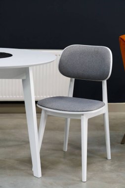 Beyaz ahşap masa, siyah ve beyaz tahta sandalyeler ve yumuşak kumaş döşeme. Masanın üzerinde siyah beyaz bir mum var.