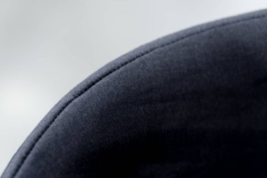 Beyaz ahşap masa, yumuşak kumaş döşemeli siyah ve beyaz sandalyelerle tamamlanmış. Masadaki siyah mum..