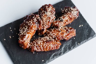 Soya soslu fırında tavuk kanadı ve kara tahtada susam tohumu.