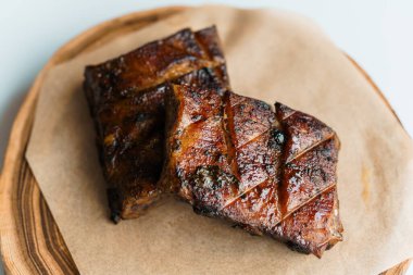 Beyaz arka planda ahşap bir tahtada soslu domuz bifteği.