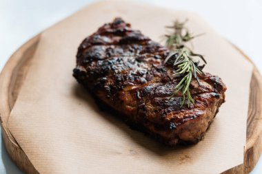 Beyaz arka planda ahşap bir tahtada soslu domuz bifteği.