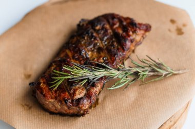 Beyaz arka planda ahşap bir tahtada soslu domuz bifteği.