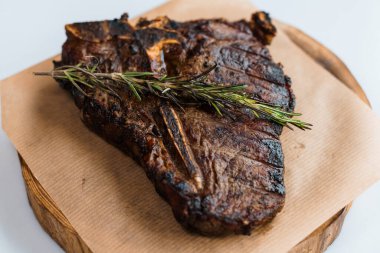 Beyaz arka planda ahşap bir tahtada soslu domuz bifteği.