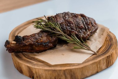 Beyaz arka planda ahşap bir tahtada soslu domuz bifteği.