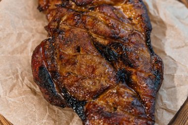 Beyaz arka planda ahşap bir tahtada soslu domuz bifteği.