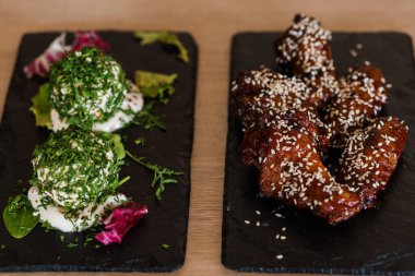 Siyah tahtada susam tohumlu soya balı tavuk kanadı.