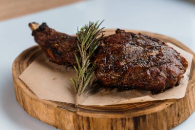 Beyaz arka planda ahşap bir tahtada soslu domuz bifteği.