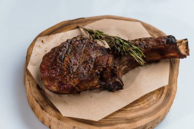 Beyaz arka planda ahşap bir tahtada soslu domuz bifteği.