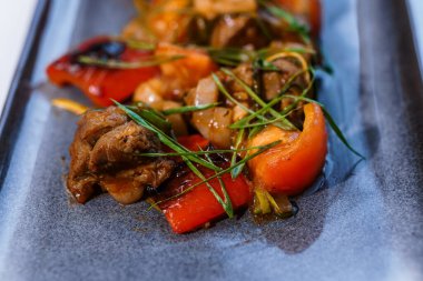 Beyaz tabakta sebzeli ve mantarlı haşlanmış et.