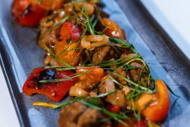 Beyaz tabakta sebzeli ve mantarlı haşlanmış et.