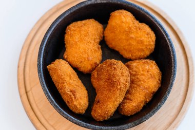 Tavuklu nuggetlar beyaz arka planda bir tabakta hamurda