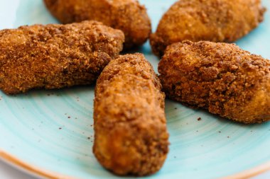 Tavuklu nuggetlar beyaz arka planda bir tabakta hamurda