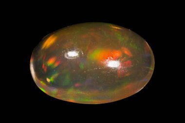 Siyah arka planda izole edilmiş doğal gökkuşağı opal mücevheri