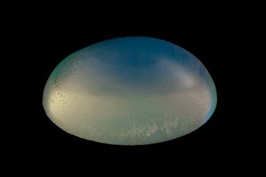 Siyah arka planda izole edilmiş doğal gökkuşağı opal mücevheri