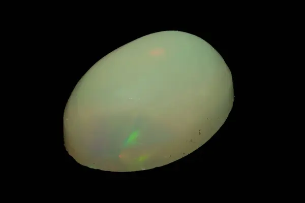 stock image natural rainbow opal gem isolated on the black background