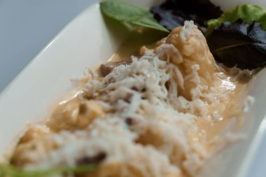 Sert peynirli patates, bir tabakta salatalık ve otlar.