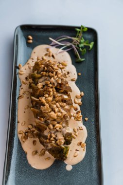 Mantar soslu haşlanmış et ve seramik tabakta otlar.