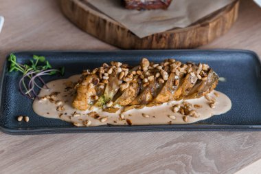 Mantar soslu haşlanmış et ve seramik tabakta otlar.