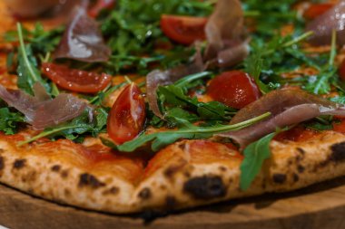 Biberli pizza, roka ve jambonlu. Peynirli et pizzası, kiraz domatesleri ve ahşap tezgahta taze roka.