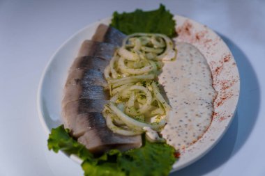 Turşulu yeşil soğan ve soslu ringa balığı.