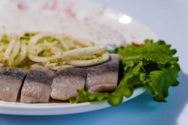 Turşulu yeşil soğan ve soslu ringa balığı.