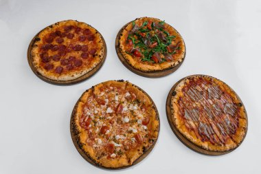 Etli ve peynirli pizza. Biberli pizza, roka ve jambonlu. Peynirli et pizzası, vişneli domates ve beyaz arka planda acı biber.