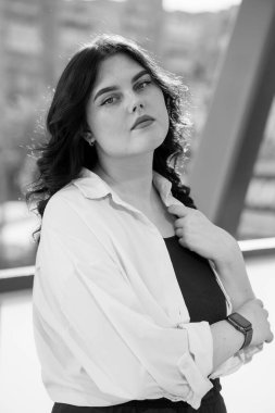 Siyah pantolonlu ve beyaz gömlekli bir iş kadını. Bir iş merkezinin geçmişine karşı siyah takım elbiseli bir iş kadını.