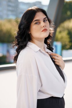 Beyaz bluzlu bir iş kadınının portresi. Beyaz gömlekli bir iş kadını portresi, arka planda bir iş merkezi var.