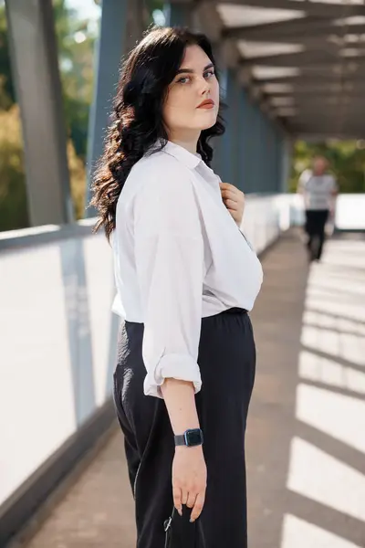 stock image Portrait of a business woman in a white blouse. Portrait of a business lady in a white shirt, with a business center in the background