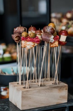 Exquisite Array of Gourmet Skewered Appetizers on Elegant Wooden Stand. clipart