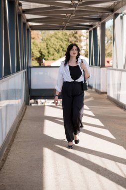 Sunlit Şehir Merkezi 'nde Yüksekte Yürüyen Kendine Güvenen Profesyonel Kadın.