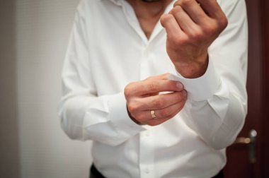 Zarif Hazırlık: Kıtır Beyaz Gömleğin Kelepçesini Resmi Durum İçin Ayarlayan Adam.