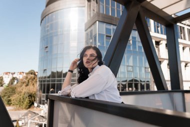 Modern Ofis Terasında Arka planda Şehir Mimarıyla Dinlenen Zarif Kadın.