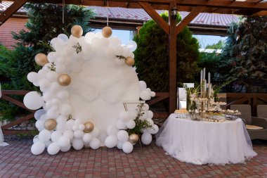 Beyaz ve Altın Balon Dekoru ve Tatlı Masası ile Zarif Açık Hava Kutlama Düzenlemesi.