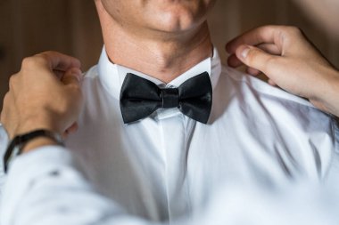 Zarif Hazırlık: Klasik Siyah Yay Kravatını Resmi Bir Olay İçin Ayarlayan Centilmen.