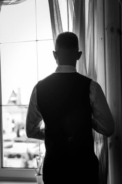 Düşünce Anı: Yelekli Zarif Adam Güneş Işığı Penceresinde Duruyor.
