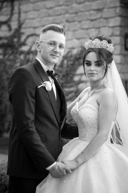 Yeni evli bir çiftin düğün gününde kucaklaşan zarif siyah beyaz portresi..