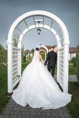 Lush Garden 'da Gelin ve Damat Yürüme Archway Altında Zarif Düğün Sahnesi.