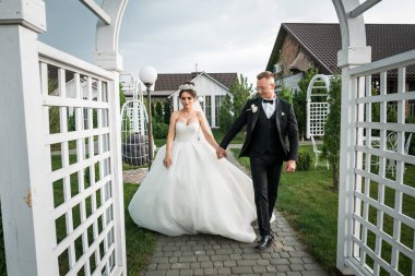 Seçkin Yeni Evli Evlenenler Düğün Günü Büyüleyici Bahçeler Archway 'inde Yürüyorlar.