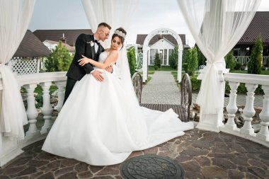 Charming Gazebo Stüdyosunda Yeni Evli Bir Çiftin Zarif Açık Hava Düğün Portresi.