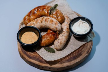 Rustik Ahşap Tahta üzerinde çeşitli soslu Gurme Sosis Tabağı.