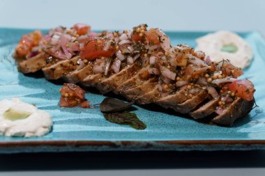 Dilimlenmiş gurme sığır filetosu Herb-Domates çeşnisi ve Zarif Seramik Tabakta Artisan Püresi.