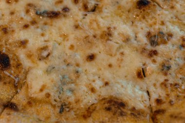 Lezzetli, kahverengi, dört peynirli, kabuklu ve erimiş peynirli pizzanın yakın çekimi. .