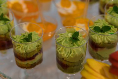 Renkli Katmanlı Tatlıların Şenlikli Büfede Taze Nane Garnitürüyle Zarif Gösterimi.